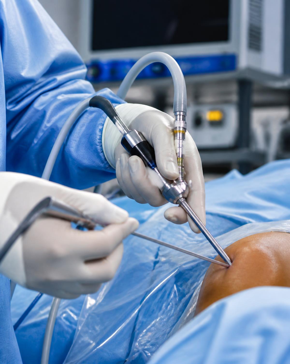 Gloved hands holding arthroscopic instruments during surgery